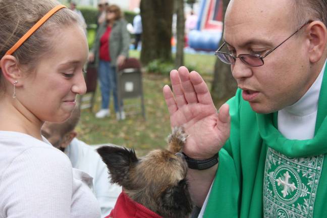 &quot;High five, Fr. Michael.&quot; The Animal Blessing Mass at Our Lady Queen of Peace Church is held annually in remembrance of St. Francis of Assisi, who loved all God's creatures. Photo by Ginny Raue