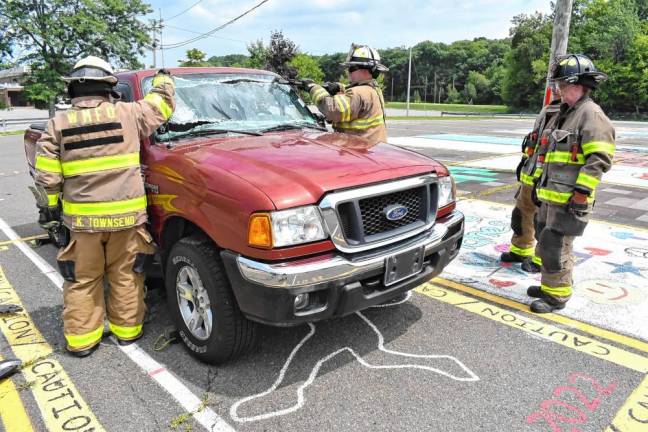 Members of Fire Company #3 remove the windshield of a vehicle.