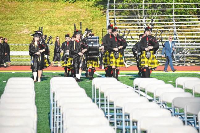 Members of the Highlander Marching Band lead the graduating seniors into the ceremony.