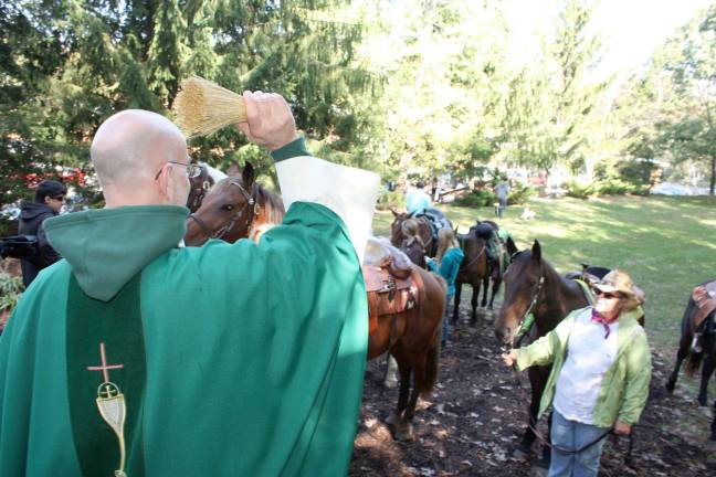 Father Steven Shadwell blesses the herd on the trail. Photo by Ginny Raue