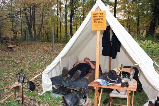 Cpt. Walter Dewey catches a few winks in the authentic camp site at Long Pond Ironworks. The poster on tent reads &quot;Recruits wanted. Come on, men! To the call.&quot; For more photos of the reenactment, go to westmilfordmessenger.com.