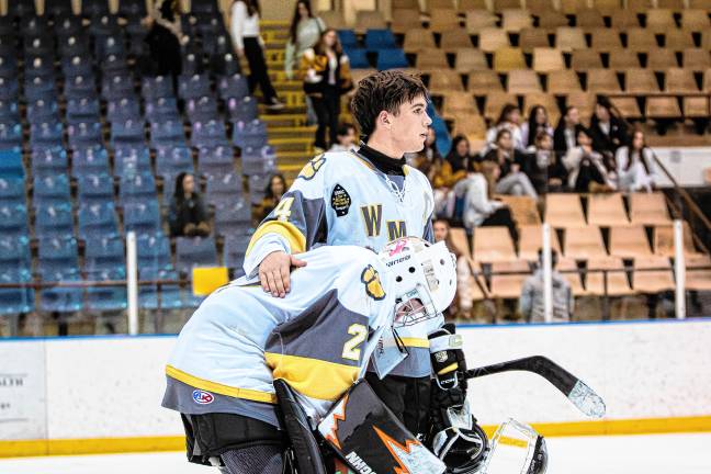 Kyle Gregory (4) consoles goalie Matthew Montena after the loss. Gregory made one assist in the game.