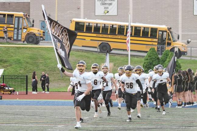 The West Milford Highlanders charge onto the field.