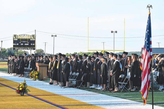 The Class of 2024 stands at commencement, which was held on McCormack Field.