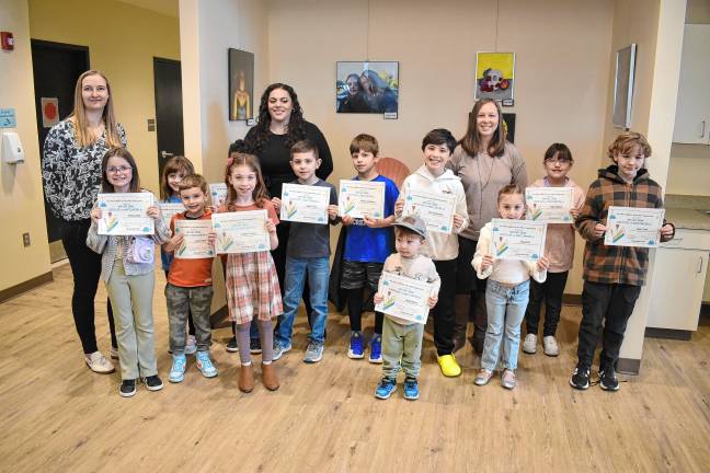 Student artists hold up their award certificates during the exhibit reception at the library. Also posing are some of their teachers. (Photos by Rich Adamonis)