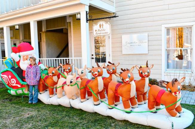 <b>Ellie Opilla of Frankford poses with Santa and his reindeer at Christmas Village at the Shoppes at Lafayette on Saturday, Nov. 30. (Photo by Maria Kovic)</b>