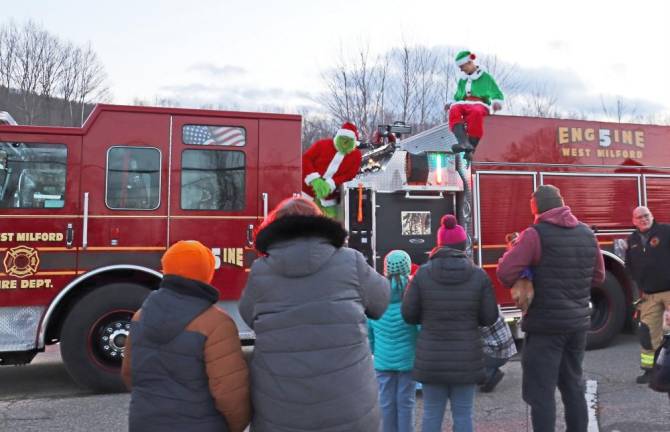 Grinch and an elf appear with Upper Greenwood Lake Volunteer Fire Co. 5 during a stop Sunday, Dec. 18 at Mt. Laurel Park in Hewitt.