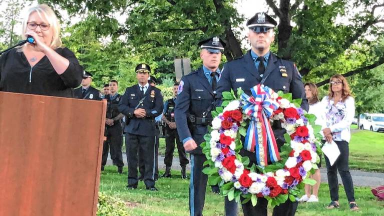 Police officers carry a wreath to the 9/11 Monument during the ceremony.