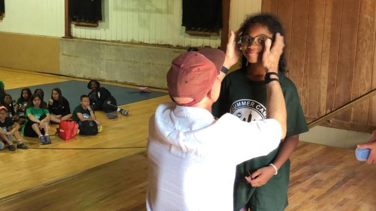 John Jonas adjusts a new pair of glasses on a camper.