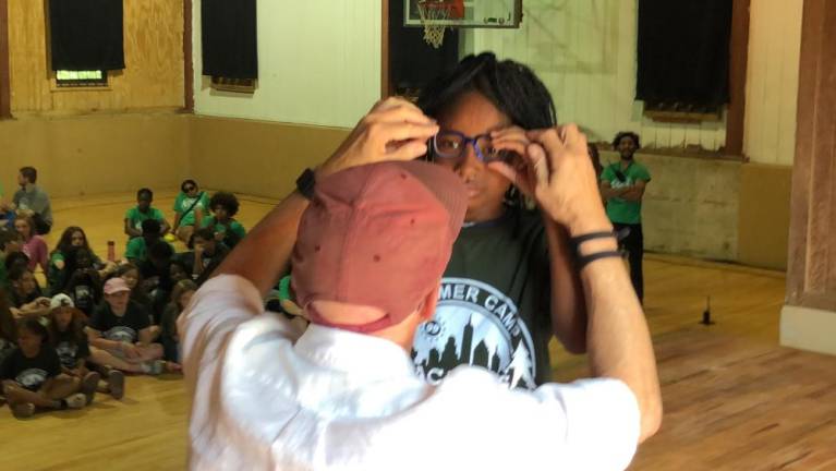 John Jonas, co-president of Jonas Philanthropies, adjusts a new pair of glasses for Ruben Benitez at Camp Vacamas in West Milford on Wednesday, July 26.