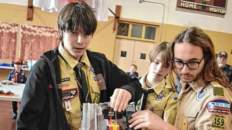 PD1 From left, Boy Scouts Steven Igielski, Griffin Kleinfelder and Colin Tornow check the racetrack at the Pinewood Derby on Sunday, Jan. 12 in the gym at Our Lady Queen of Peace Church in Hewitt. (Photo by Rich Adamonis)