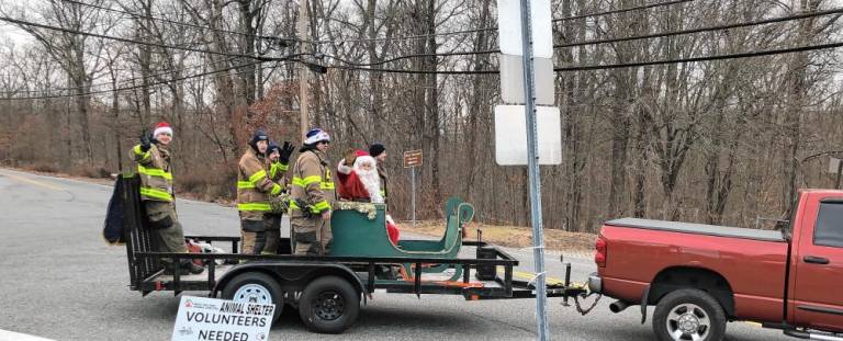 Firefighters with Greenwood Forest Volunteer Fire Company #3 escort Santa through West Milford neighborhoods Sunday, Dec. 15. (Photo by Kathy Shwiff)