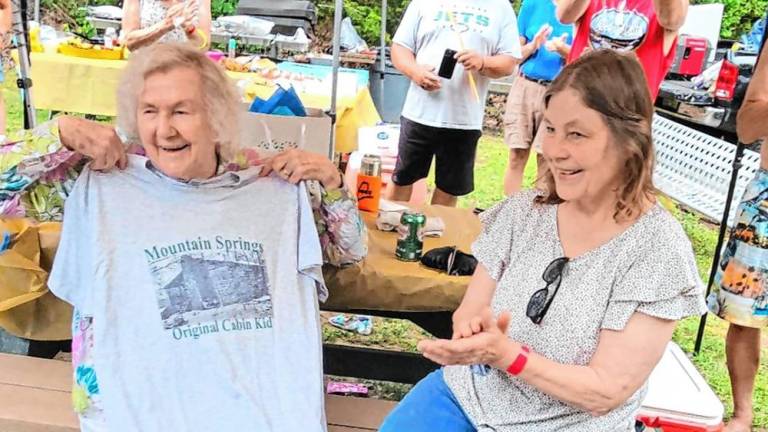 Judy Dorph-Ocello, right, Mountain Springs treasurer and owner of Stonehill Estates Kennel, presents Ellen Foster, 96, with an ‘Original cabin girl’ T-shirt at the Mountain Springs centennial celebration July 20. (Photo provided)