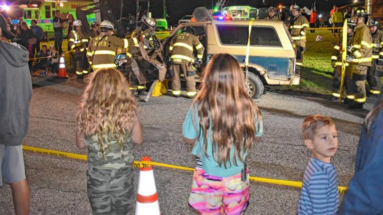 Residents watch a demonstration by firefighters using the ‘Jaws of Life’ to free a trapped motorist during the National Night Out event Tuesday, Oct. 1 at West Milford High School. (Photo by Fred Ashplant)